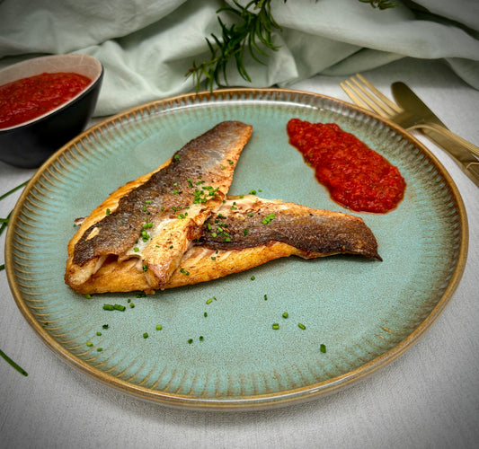 Op de huid gebakken zeebaarsfilet met romescosaus